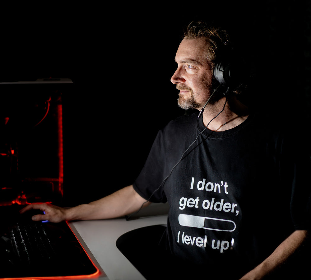 I Don't Get Older, I Level Up t-shirt, worn at a gaming desk after dark